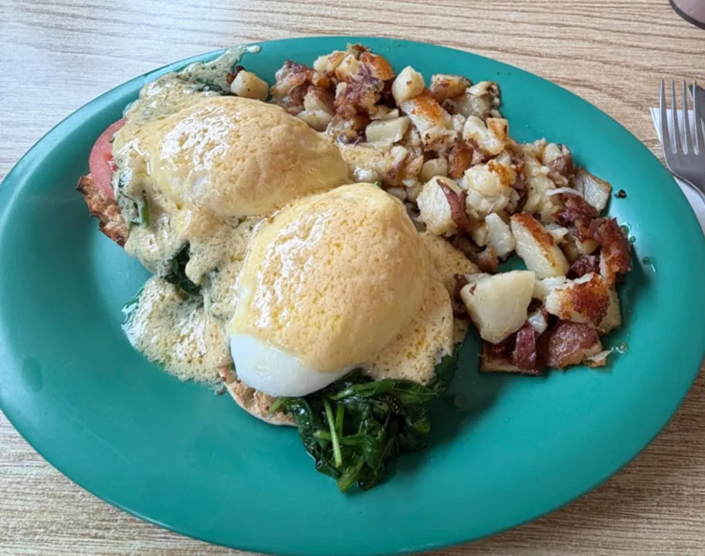 A plate of eggs, potatoes, and greens made with local ingredients